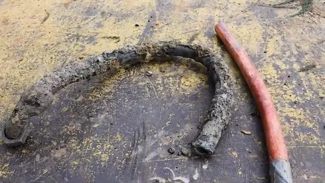 A technician handling feeding copper water line through wall opening.