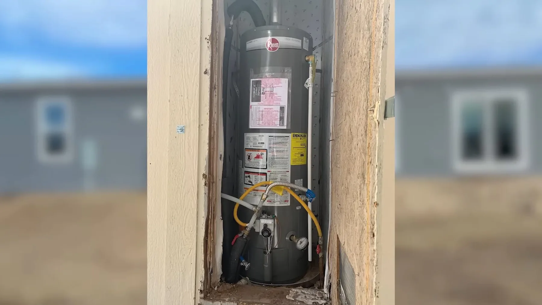 The water heater visible through wall opening captured during an inspection.